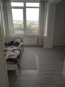 um quarto com uma cama e uma grande janela em Apartament Panorama Kalisz Złota 71 em Kalisz