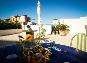 eine Terrasse mit einem Tisch, Stühlen und einem Sonnenschirm in der Unterkunft Fermata 135 B&B in Grottammare