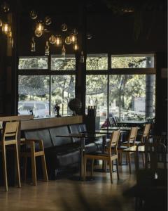 a dining room with tables and chairs and windows at Hotel Plaza in Colón