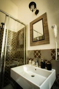 ein Bad mit einem Waschbecken, einer Dusche und einem Spiegel in der Unterkunft Fermata 135 B&B in Grottammare