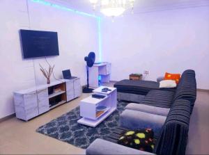 uma sala de estar com um sofá e uma televisão de ecrã plano em Dezra Homes em Lagos