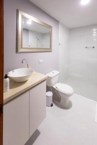 a white bathroom with a sink and a toilet at Casa Palmar Cartagena in Cartagena de Indias