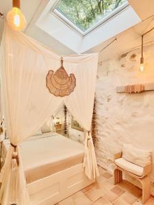 a bedroom with a canopy bed and a window at Histoire de cru in Saignon +41 photos