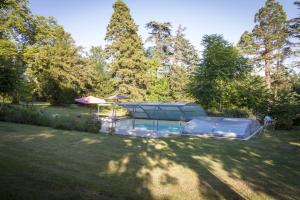 a swimming pool in a yard with trees at Le Gavachon in Leboulin