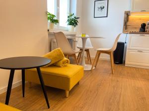 a living room with a yellow chair and a table at Modern Oasis in the Heart of the City in Košice