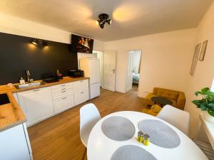 a kitchen and dining room with a white table and chairs at Modern Oasis in the Heart of the City in Košice