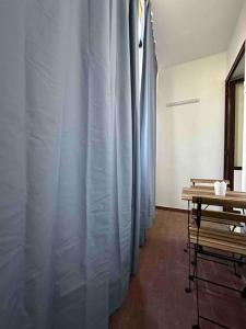 una fila di tende blu in una stanza con tavolo di Gioia Guest House a Torre del Greco