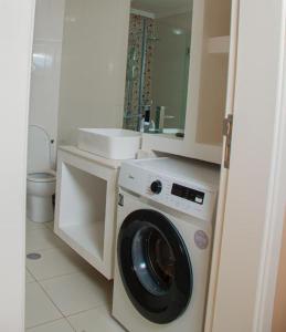 a bathroom with a washing machine and a sink at The Queen in Luanda