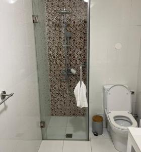 a bathroom with a shower with a toilet and a sink at The Queen in Luanda