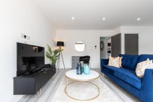 sala de estar con sofá azul y mesa en LUXURIOUS Apartments FREE parking and FREE WiFi!, en Staines