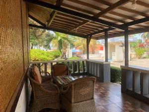 Hotel Pantai Mutiara في بلابون راتو: شرفة مع كراسي الخوص و pergola