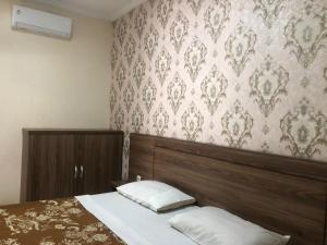 1 dormitorio con cama y pared con papel pintado en Hotel Pantai Mutiara, en Pelabuhan Ratu