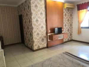 una habitación con TV en un escritorio y una habitación sin intención de hacerlo en Hotel Pantai Mutiara en Pelabuhan Ratu