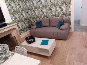 a living room with a couch and a table at Cocon une surprise vous attend à Dunkerque in Dunkerque