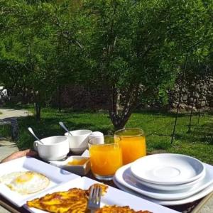 a table with plates of food and glasses of orange juice at Royal Heritage Nagar in Maiūn
