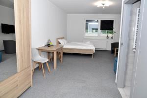1 dormitorio con cama, escritorio y mesa en Pokoje, Apartamenty, Restauracja Marcus en Oborniki