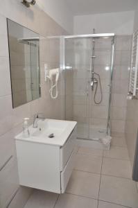 baño blanco con ducha y lavamanos en Pokoje, Apartamenty, Restauracja Marcus, en Oborniki