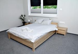 1 dormitorio con 1 cama con sábanas blancas y ventana en Pokoje, Apartamenty, Restauracja Marcus, en Oborniki