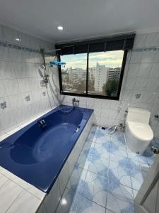 a bathroom with a blue tub and a toilet at Pattaya beach condo in Pattaya
