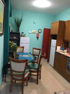 a kitchen with a table and chairs and a kitchen with a refrigerator at Noer Hostel in Larnaka