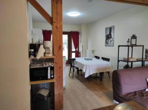 uma sala de estar com uma cozinha e uma mesa com um micro-ondas em gîte le Ranch de Vassiviére em Royère-de-Vassivière