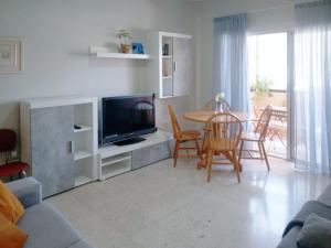 un soggiorno con TV, tavolo e sedie di Live Puertito Cortes a Puertito de Güímar