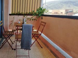 balcone con tavolo, sedie e finestra di Live Puertito Cortes a Puertito de Güímar