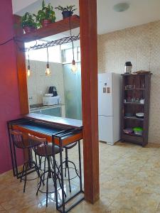 cocina con barra con sillas y nevera en Hostel Dela, en Tiradentes