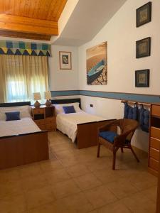 a bedroom with two beds and a chair and a couch at Saleros in Navarrete