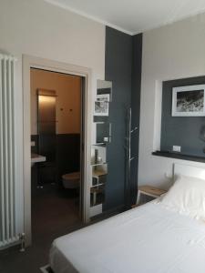 a bedroom with a bed and a bathroom with a sink at Stanze Ildesco in Bergamo