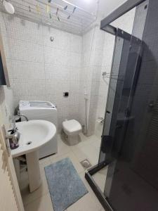 y baño con aseo, lavabo y ducha. en Espaçoso Apartamento no Centro, en Río de Janeiro