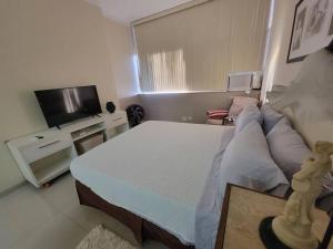 1 dormitorio pequeño con 1 cama y TV en Espaçoso Apartamento no Centro, en Río de Janeiro
