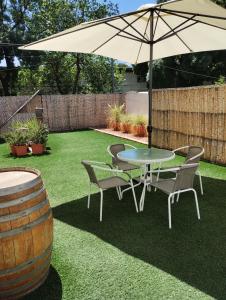 a patio with a table and chairs and an umbrella at LA BARRICA ESTUDIO, Departamento funcional, comodo, acogedor y completamente equipado en el Centro de Mendoza Capital, con hermosa terraza para disfrutar, No pierdas esta oportunidad! in Mendoza