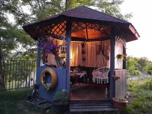 a gazebo with a table and a chair in a yard at Camping place in Alba Iulia