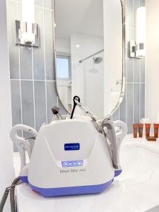 a hair dryer on a bathroom counter in front of a mirror at Oasis by the Bay Vacation Suites in Wasaga Beach +73 photos