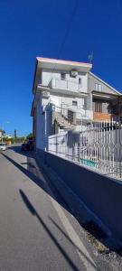 a white building with a fence next to a street at Moon in Pignataro Maggiore