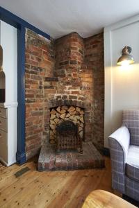 a brick fireplace in a living room with a couch at The Royal in Wallingford