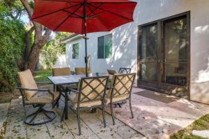 - une table et des chaises avec un parasol rouge sur la terrasse dans l'établissement Beautiful LA Home with Hot Tub about 14 Mi to Hollywood!, à Tarzana