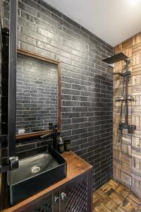 a bathroom with a sink and a brick wall at Paplūdimio namukas in Molėtai