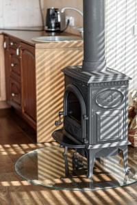 a black stove sitting in the middle of a kitchen at Paplūdimio namukas in Molėtai