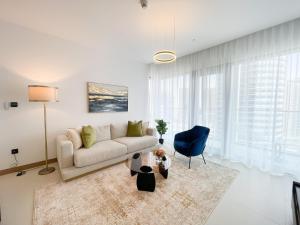 a living room with a couch and a blue chair at Luxury living at Vida Marina & Yacht Club in Dubai