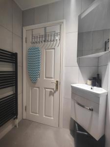 uma casa de banho com uma porta branca e um lavatório em Self-contained flat, off street parking close to town and beach em Bournemouth