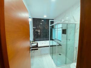 een badkamer met een glazen douche en een toilet bij Pousada D'avilas in Monte Verde