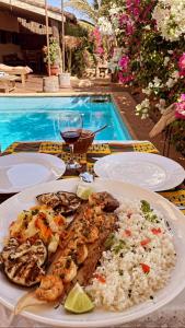 a plate of food on a table next to a pool at Villas Badiene in Poponguine