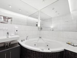 a white bathroom with a tub and a sink at SKY9 Apartments District 6 (Mariahilfer Straße) in Vienna