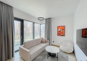 Luxury living at Vida Marina & Yacht Club في دبي: غرفة معيشة بيضاء مع أريكة وطاولة