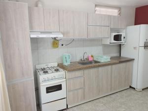 ルハン・デ・クージョにあるDepartamento Carrodilla Lujánのキッチン(白いコンロ、冷蔵庫付)