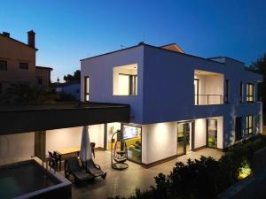 a large blue house with a swimming pool at night at Neptunia - 4 bedroom villa in Medulin