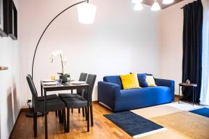 a living room with a blue couch and a table at Delightful shanti home in Milan