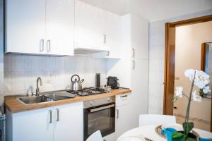 una cocina con armarios blancos y fregadero en Delightful shanti home en Milán